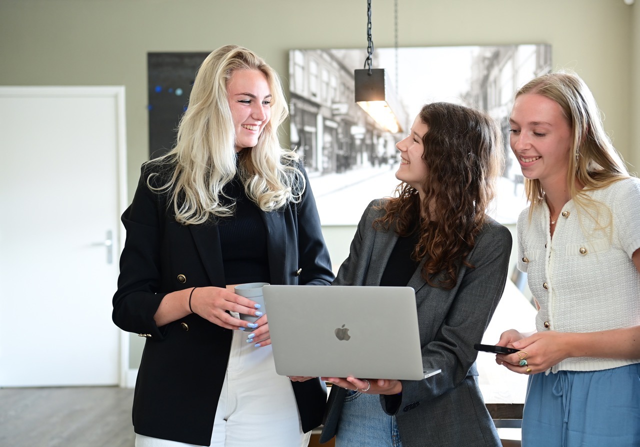 3 marketeers bespreken social media marketing met een laptop